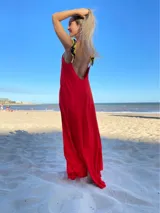 Vestido largo rojo con breteles finos amarillos con estampado floral negro y espalda descubierta.