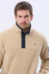 Buzo de abrigo confeccionado en tejido polar térmico, con cuello alto y cierre frontal parcial con broches. Presenta bolsillos laterales con cierre y un bolsillo adicional con cierre en la manga izquierda.