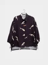 Camisa de manga larga color rosa con rayas verticales rojas y estampado de flores rojas. Con cuello camisero, puños elastizados y lazos regulables en los costados del ruedo.