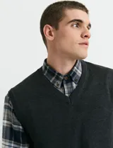 Camisa de franela a cuadros con cuello button-down, manga larga y botones de madera. Presenta dos bolsillos tipo parche en el frente con cierre de botón.