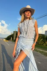 Conjunto de dos piezas en color amarillo, compuesto por un top sin mangas con textura plisada y una falda midi con frunce lateral ajustable que permite regular la abertura frontal.