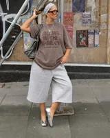 Remera oversize color beige con efecto acid wash y estampa frontal en marrón con la frase "Killing In The Name Of".