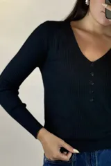 Buzo de hilo gris con textura acanalada, escote en V y cierre frontal con botones pequeños.