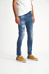 Pantalón de jean azul de corte ajustado con roturas en las rodillas.