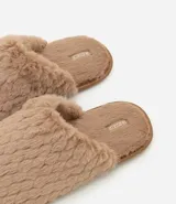 Pantufla cerrada de mujer con textura de peluche suave en color negro, diseñada para brindar comodidad en el hogar.
