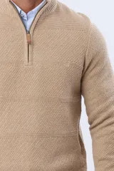 Buzo tejido texturado color beige, con cuello alto y cierre frontal parcial con detalle de cuero.