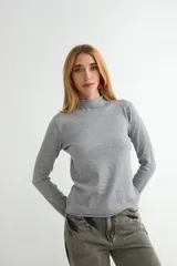 Polera de cuello alto y manga larga, confeccionada en tejido de punto fino con acabado liso.