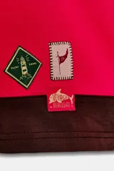 Polo de manga larga con cuello solapa y cierre frontal de botones. Diseño a rayas horizontales anchas en color negro y rojo. Presenta texto bordado en el pecho y parches decorativos en la parte inferior delantera.