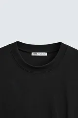 Remera blanca de corte relajado, con cuello redondo y mangas cortas.