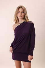 Vestido corto color gris oscuro, con escote asimétrico dejando un hombro al descubierto, mangas largas y corte holgado.