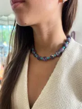 Collar de cuentas de piedra natural en tonos verde y lila, intercaladas con cuentas turquesas y detalles dorados.