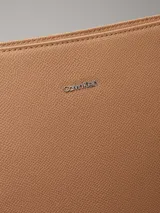 Cartera tipo saco color tostado de cuero sintético granulado, con correa de hombro ajustable de cuero sintético y correa bandolera ajustable de jacquard con logo.