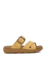 Sandalia de color amarillo claro con diseño de doble tira cruzada en el empeine, una de ellas ajustable con hebilla grande. Suela de plataforma baja con textura tipo corcho.