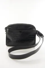 Bandolera semirrígida Sagali de cuero vacuno color bordó, con textura de cocodrilo en el bolsillo frontal y cuerpo liso. Cuenta con cierre superior y correa regulable.
