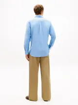 Camisa de corte regular confeccionada en algodón Oxford elástico y ligero, color celeste. Cuenta con cuello abotonado, mangas largas con puños redondeados, bolsillo de parche en el pecho con el logo bordado y bajo redondeado.