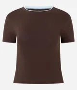 Remera de algodón ajustada al cuerpo, color marrón oscuro, con cuello redondo y ribete contrastante blanco en el cuello y los bordes de las mangas cortas.
