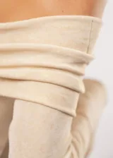 Blusa beige con hombros descubiertos, mangas largas acampanadas y confeccionada en tela stretch con lurex.