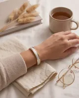 Pulsera esclava rígida de plata 925 y lámina de oro 18k, con banda central texturizada en tono blanco con acabado brillante.