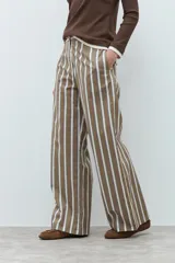Pantalón de corte recto y tiro medio, con diseño de rayas verticales en tonos marrón, blanco y azul. Cuenta con cierre frontal y bolsillos laterales.