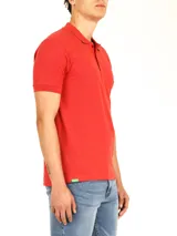 Polo de piqué color rojo, manga corta, con cuello y tapeta de botones al tono.