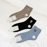 Pack de tres pares de medias de caña media acanaladas, en color beige, negro y celeste, con bordado de animales en el tobillo.