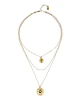 Collar triple dorado con cadena fina y dos dijes de ojo con cristal verde facetado. El collar es de aleación de metales bañado en oro de 18k.