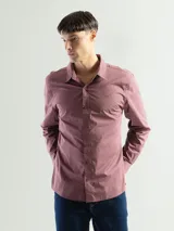 Camisa de manga larga color azul marino, confeccionada en algodón, con cuello abotonado (button-down) y un pequeño logo bordado en el pecho.