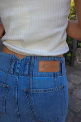 Falda larga de jean azul claro, con tajo trasero, pretina con doble botón y cierre metálico.