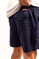 Bermuda azul marino de lino tipo cargo, con bolsillos laterales y traseros, elástico en la parte de atrás, cierre y botón en el frente.
