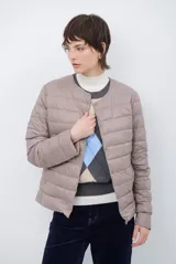 Campera acolchada tipo puffer en color beige, con diseño sin cuello y cierre frontal con botones a presión.