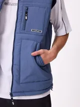 Chaleco reversible de nylon con diseño acolchado, cuello alto y cierre frontal. Cuenta con un bolsillo con cierre en el pecho y bolsillos laterales, además de una etiqueta con el logo de la marca.