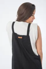 Mono negro de denim con corte oversize, breteles anchos y piernas anchas.