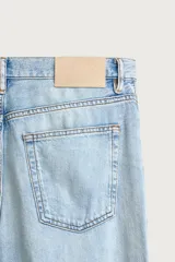 Jeans de corte regular cropped confeccionados en denim ligero de algodón. Presentan un diseño de cinco bolsillos con efecto lavado, tiro medio y cierre frontal con botones.