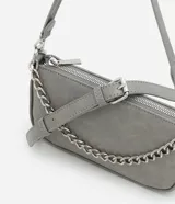 Cartera tipo baguette color gris, confeccionada en poliuretano con acabado mate. Presenta un diseño minimalista con cierre superior por cremallera, una cadena decorativa plateada en el frente y una correa larga ajustable y desmontable.