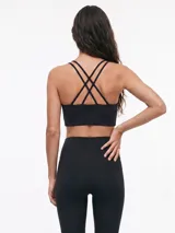 Top deportivo negro de diseño liso con escote redondo y tirantes dobles finos en los hombros.