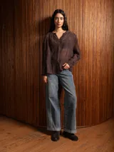 Blusa de tela liviana color bordó, con escote en V y detalles de bordado floral tono sobre tono. Presenta mangas largas con leve volumen y puños abotonados.