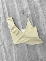 Top de bikini fucsia con un solo tirante y volados en el escote.