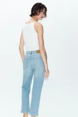 Jeans de tiro alto con corte mini flare y largo tobillero. Presentan diseño de cinco bolsillos, pernera estrecha con acabado evasé y cierre frontal con cremallera y botón.