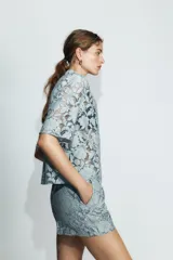 Shorts de tiro alto confeccionados en encaje con diseño floral. Presentan bolsillos delanteros y cierre frontal con cremallera y gancho metálico.