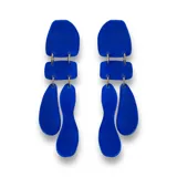 Aros colgantes color rojo con piezas geométricas irregulares unidas por argollas plateadas.