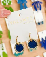 Aros colgantes con forma circular, color azul con borde de strass plateado y gancho dorado.