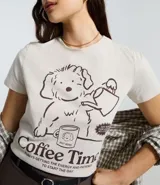 Remera de algodón con cuello redondo y manga corta. Presenta un diseño estampado en el frente con un dibujo de un perro y la inscripción Coffee Time.