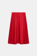 Falda midi de tiro alto y corte en A, color rojo, con bolsillos laterales ocultos y cierre lateral con cremallera.