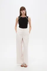 Pantalon sastrero ancho de tiro alto, color beige, con bolsillos y cierre frontal con botón.