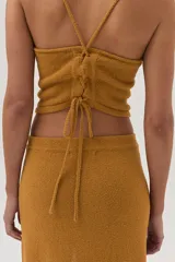 Falda midi color mostaza, tejida con textura y corte en el frente.