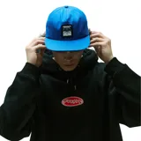 Gorra de visera plana color azul con parche frontal negro que contiene dos imágenes en blanco y negro, posiblemente resonancias magnéticas o escaneos cerebrales.