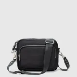 Cartera tipo bandolera de color celeste, con diseño acolchado horizontal, tres compartimentos exteriores con cierre y correa ajustable negra con logo de la marca.
