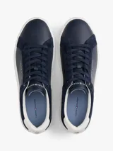 Zapatillas de corte bajo Tommy Hilfiger, confeccionadas en una combinación de piel nobuk y piel lisa en color azul marino. Presentan suela de goma blanca, cierre con cordones y detalles de la marca en el lateral, lengüeta y talón.