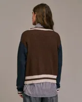 Cárdigan con estampado de rombos en tonos marrón, beige y azul, con cuello en V y cierre frontal con botones. Mangas largas y ribete acanalado en puños y bajo.