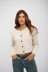 Saco de punto color beige, con cuello redondo, cierre frontal de botones oscuros y dos bolsillos delanteros. De corte recto y manga larga.